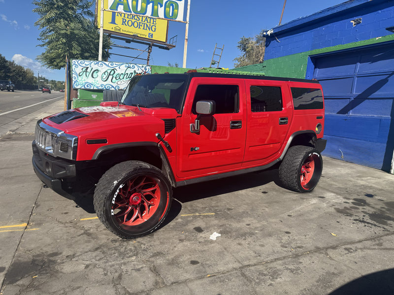 Red Hummer H2 on red custom wheels with white-letter tires