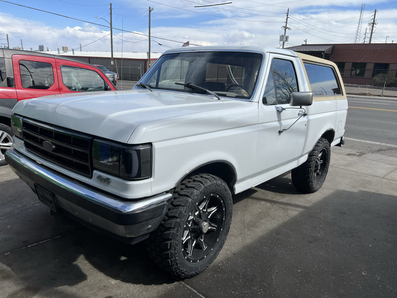 White Ford Bronco on black off-road wheels