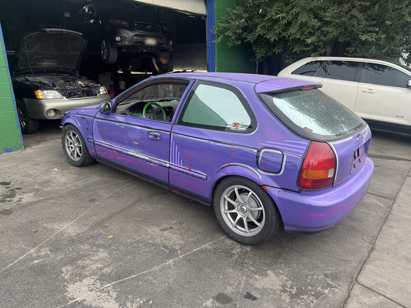 Purple Honda Civic hatchback outside a shop bay