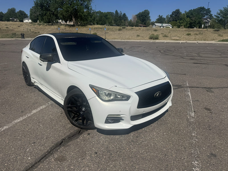 White Infiniti sedan with a black roof and black wheels